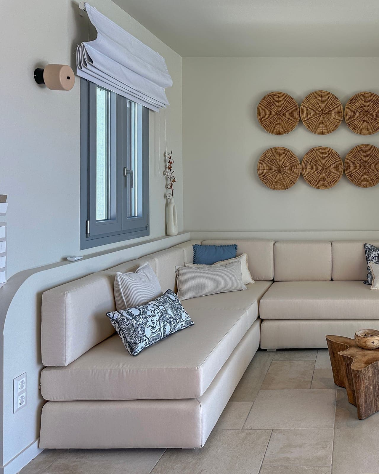 Living room with a linen sofa and woven wall discs